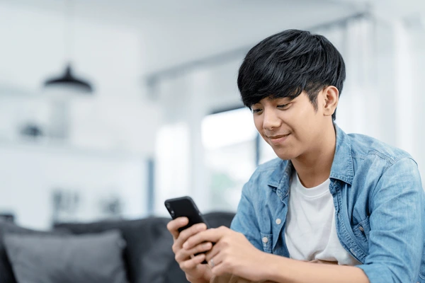 Asian guy using social media on the phone